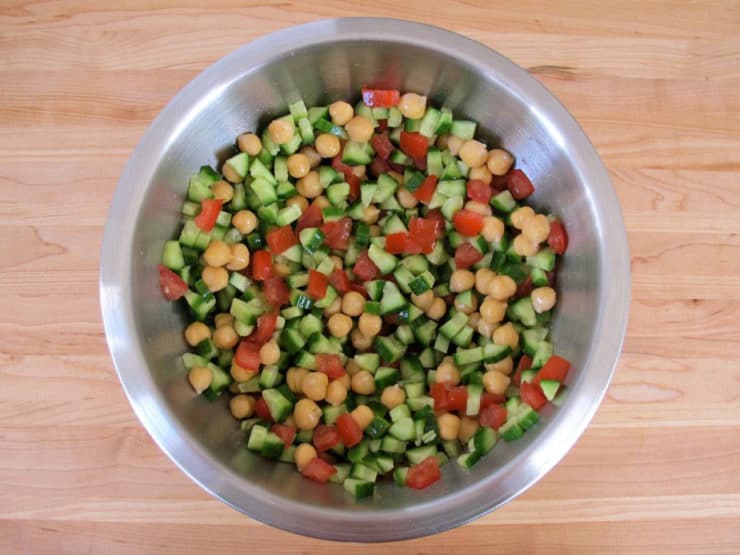 Chickpeas and diced vegetables in a mixing bowl.
