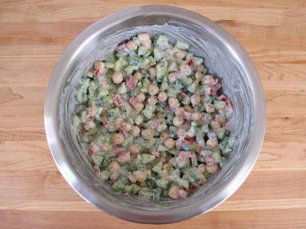 Tossing salad with dressing.