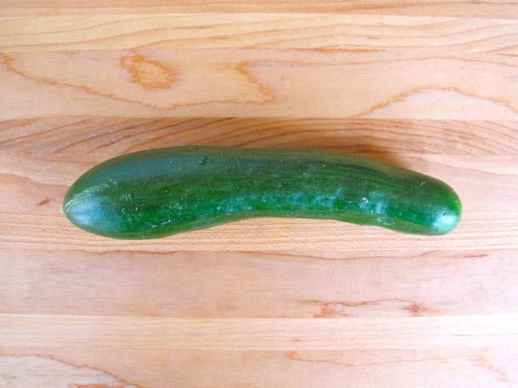 Persian cucumber on wooden cutting board.