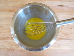 Whipping eggs in a small bowl.