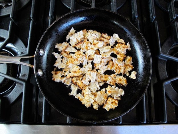 Crumbled matzo in a buttered skillet.