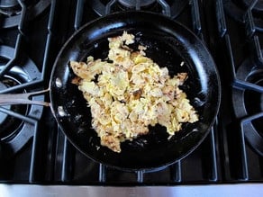 Crumbled matzo in a buttered skillet.