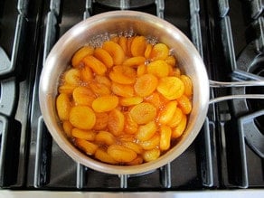 Dried apricots simmering in a saucepan.