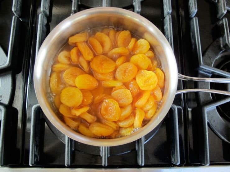 Dried apricots in orange juice in a saucepan.