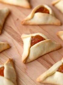 Hamantaschen cookies with apricot filling - lekvar apricot butter - on a wooden background.