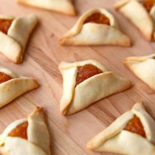 Hamantaschen cookies with apricot filling - lekvar apricot butter - on a wooden background.