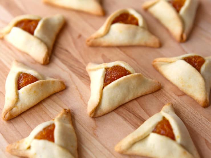 Hamantaschen cookies with apricot filling - lekvar apricot butter - on a wooden background.