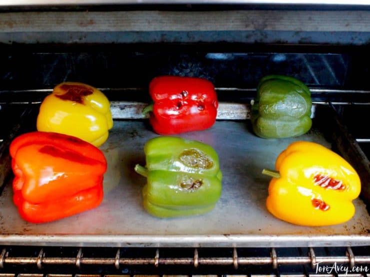 Colorful bell peppers blackened on baking sheet.