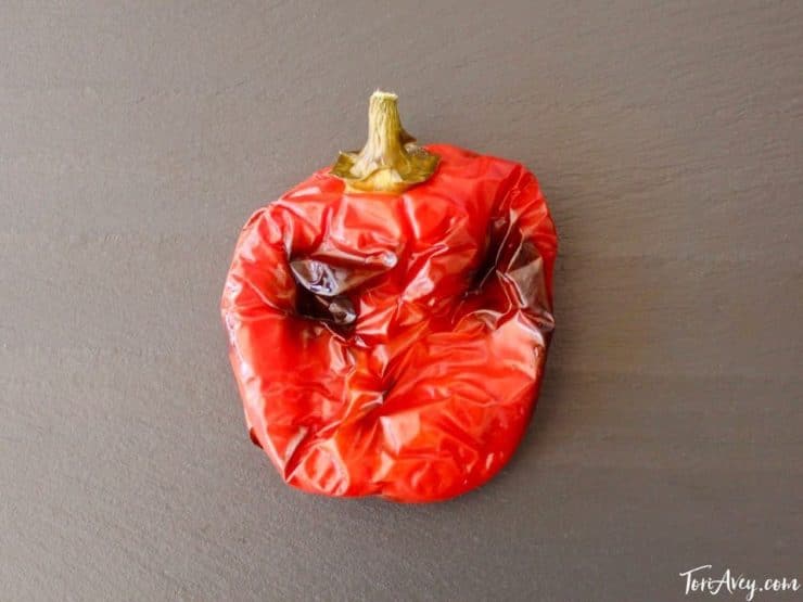 Roasted red bell pepper on cutting board.