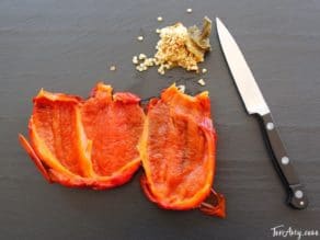 Roasted seeded red bell pepper on cutting board.