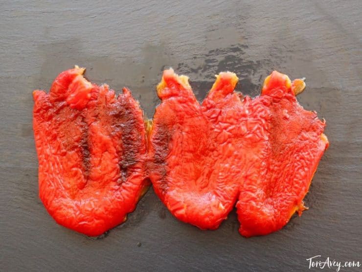Roasted peeled red bell pepper on cutting board.