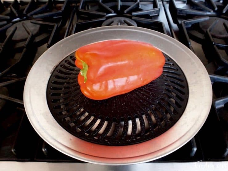 Red bell pepper roasting on grill pan.