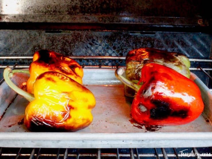Colorful bell peppers blackened on baking sheet.