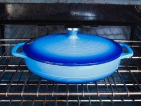 Blue cast iron casserole dish in oven.