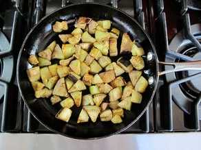 Diced eggplant in a skillet.