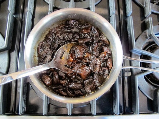 Stirring brown sugar into prune filling.
