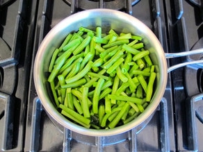 Blanching green beans in a saucepan.