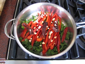 Bell peppers and cilantro in the bottom of a saute pan.