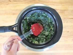 Squeezing moisture out of steamed spinach.