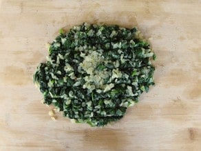 Chopped spinach on a cutting board.