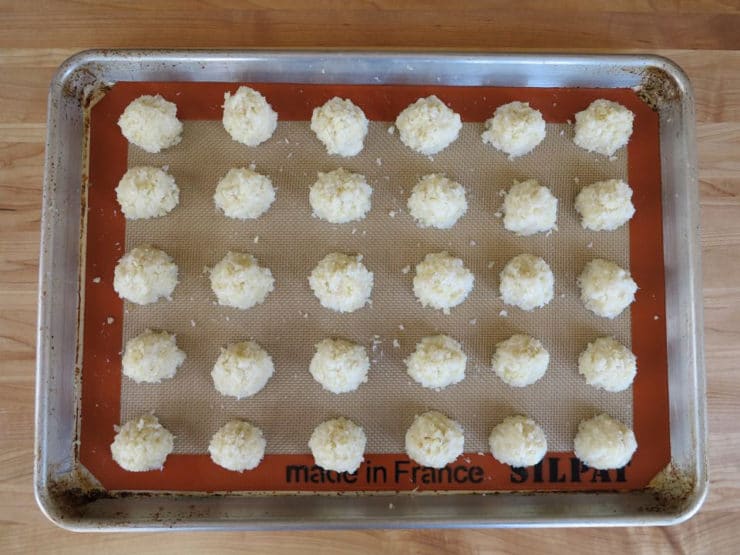 Shaping macaroons on a silpat lined baking sheet.