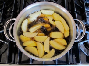 Sliced apples in a pot of water.
