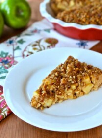 A slice of Passover Apple Pecan Pie featuring apple crisp and walnuts on a white plate