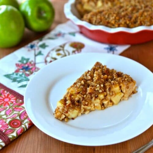 A slice of Passover Apple Pecan Pie featuring apple crisp and walnuts on a white plate