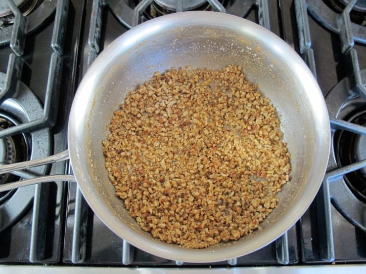 Chopped pecans stirred into brown sugar syrup.