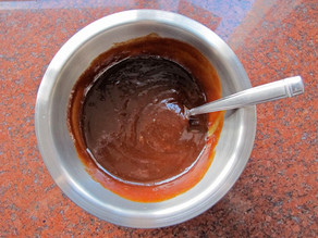 Stirring honey into barbecue sauce.