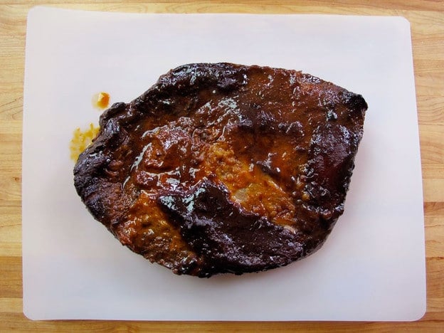 Cooked beef brisket on a cutting board.