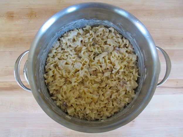 Creamy sauce mixed into pot of noodles.