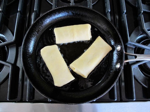 Frying blintzes in a skillet.