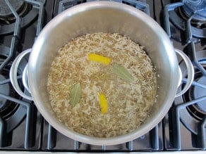 Spices and water in stockpot with rice and lentils.