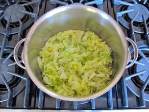 Steamed cabbage strips in a pot.