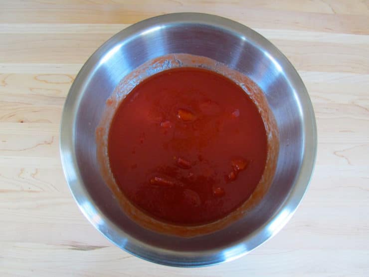 Tomato sauce and seasoning in a mixing bowl.