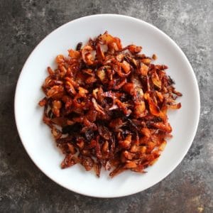 Overhead shot of crispy gribenes on a plate on concrete background.