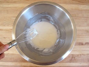 Whisking icing in a bowl.