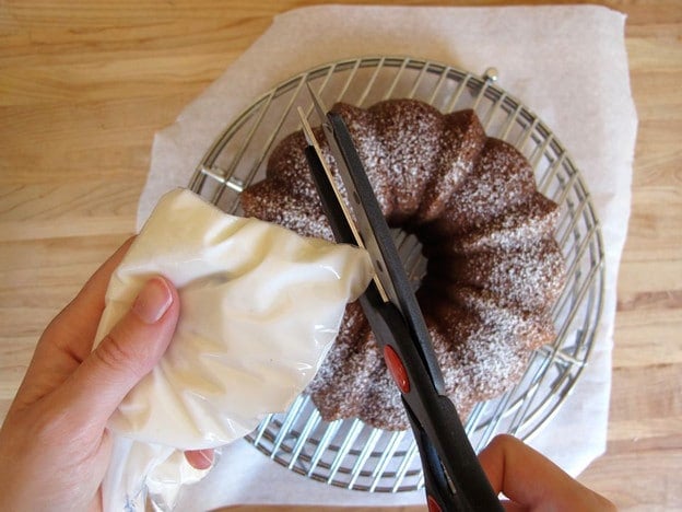Snipping the tip off a ziptop bag filled with icing.