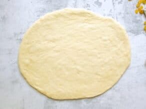 Overhead shot of challah dough that has been rolled into an oval shape.