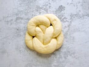 Dough formed into 5 linked loops to create a beautiful unbaked round challah shape.