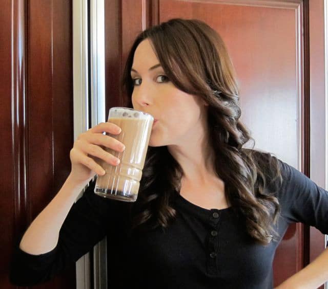 Tori Avey drinking a delicious chocolate egg cream in a tall glass