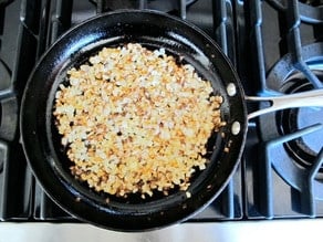 Diced onion frying in a skillet.