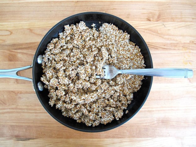 Breaking up cooked kasha with a fork.