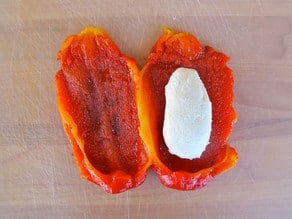 Goat cheese placed on red pepper half.
