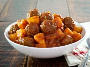 Bowl of sweet and sour meatballs with pineapple.