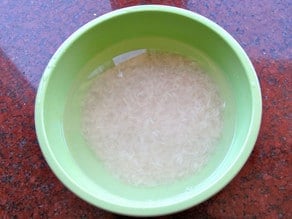 White rice soaking in a bowl of water.