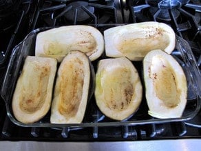 Eggplant halves on a baking sheet.