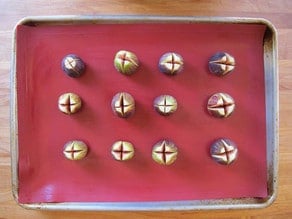 Figs cut open in an X, on a lined baking sheet.