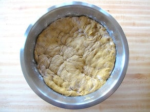 Challah dough punched down in a bowl.